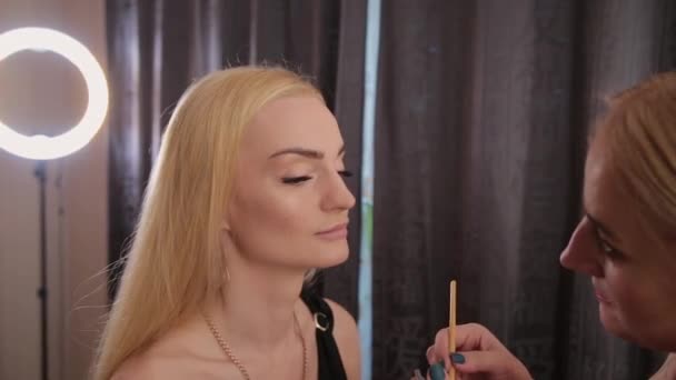 Επαγγελματίας καλλιτέχνης μακιγιάζ κάνει μακιγιάζ μια πολύ όμορφη γυναίκα. — Αρχείο Βίντεο
