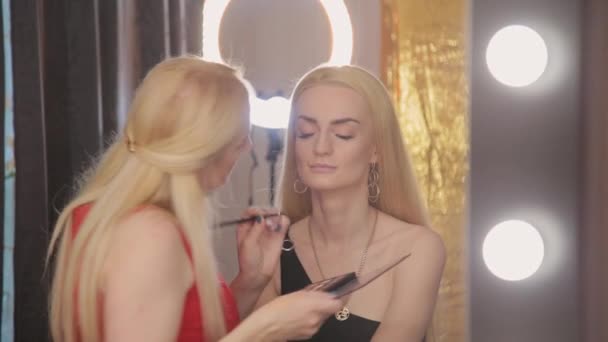 Artista de maquillaje profesional hace que el maquillaje una mujer muy hermosa . — Vídeos de Stock