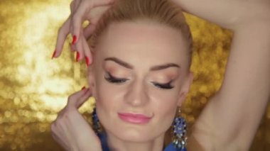 Güzel güzellik model altın arka plan üzerinde poz.