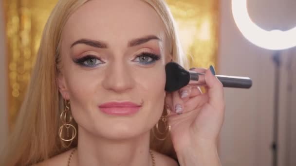 Professional makeup artist makes makeup a very beautiful woman. — Stock Video