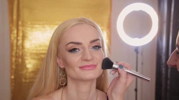 Professional makeup artist makes makeup a very beautiful woman. — Stock Video