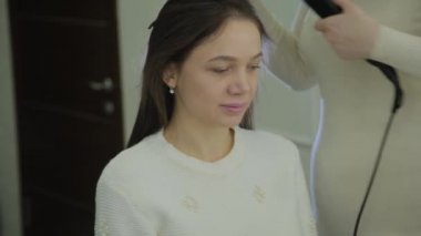 Maşa ile bir Kuaför tarafından tedavi kahverengi saçlı güzel kadın yaşıyor. El gerçek zamanlı çekim kurma.