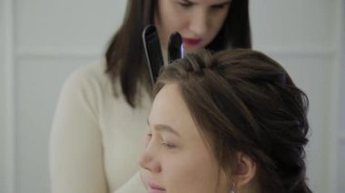 Maşa ile bir Kuaför tarafından tedavi kahverengi saçlı güzel kadın yaşıyor. El gerçek zamanlı çekim kurma.