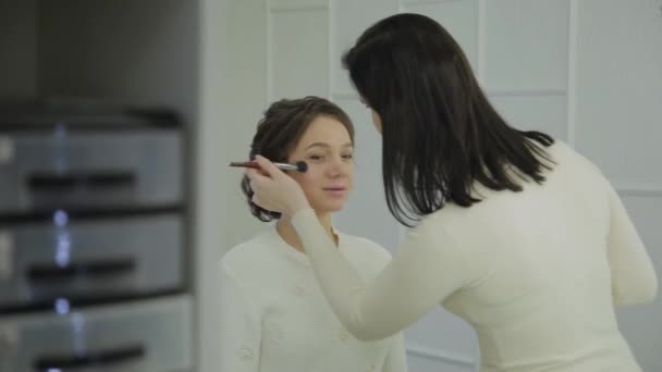 Profesionální vizážistka dělá make-up velmi krásná žena. — Stock video