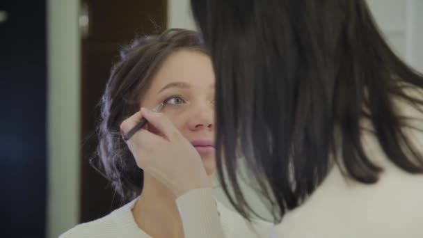 Maquilleuse professionnelle fait du maquillage une très belle femme . — Video