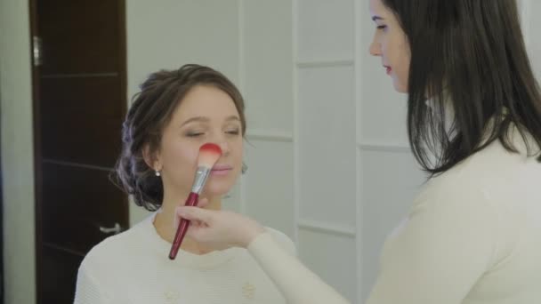 Profesionální vizážistka dělá make-up velmi krásná žena. — Stock video