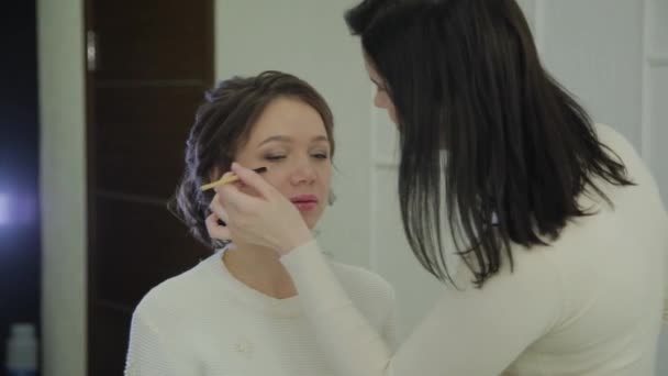 Επαγγελματίας καλλιτέχνης μακιγιάζ κάνει μακιγιάζ μια πολύ όμορφη γυναίκα. — Αρχείο Βίντεο