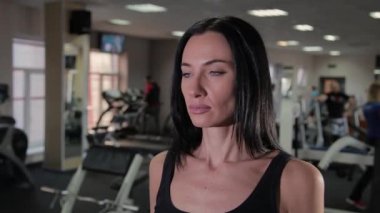 Güzel atletik genç kız dumbbells pazı salonunda trenler.