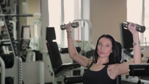 Très belle femme fitness faisant de l'exercice avec des haltères dans la salle de gym . — Video