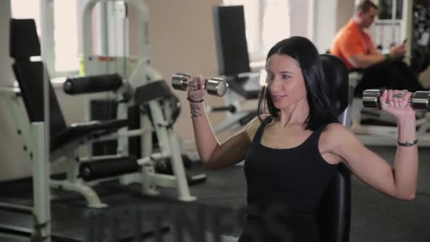 Nagyon szép fitness nő gyakorlása a tornateremben súlyzók. — Stock videók