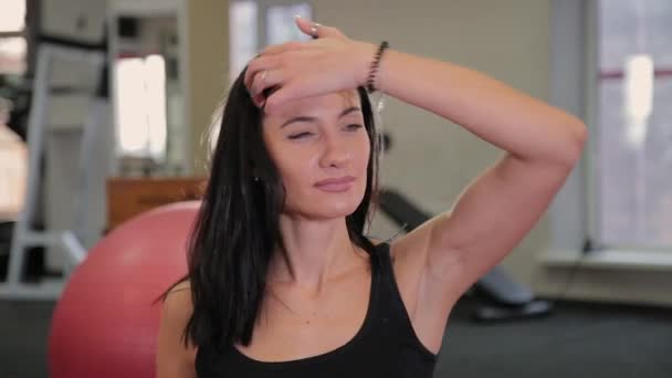 Bella donna seduta stanca dopo l'allenamento di fitness . — Video Stock