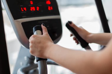 Atletik kız spor salonu yan görünümünde bir elipsoid yapıyor. Kadın trende bir elipsoid. Spor ve sağlıklı yaşam konsepti.