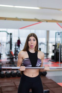 Güzel kız halter salonunda katta kullanarak pazı trenler.