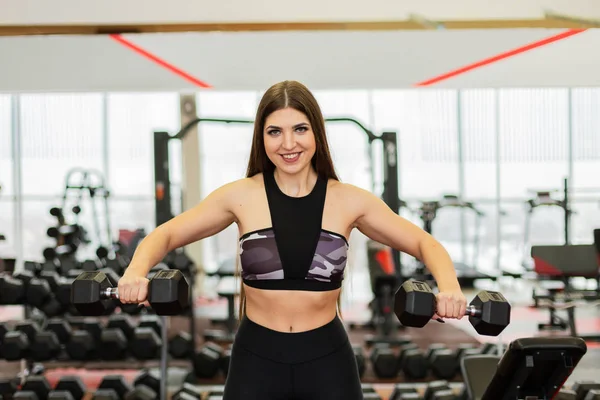 Hermosos trenes hombros con mancuernas en el gimnasio . — Foto de Stock