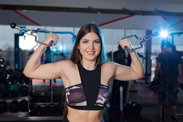 Very beautiful girl trains hands on blocks in the gym — Stock Photo, Image