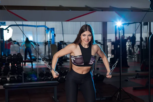 Mycket vacker flicka tränar händer på block i gymmet — Stockfoto