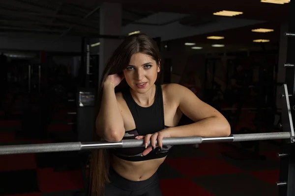 Krásné sexy fitness model citově představuje v atletické činka v posilovně. — Stock fotografie