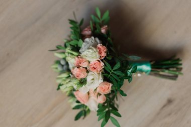 Düğün buketi kutlama öncesi hazırlık sırasında gri halı üzerinde yalan. Dekoratif gül yan görünüm çiçekler ve buket bırakır. Çiçek buketi evlilik dekorasyon