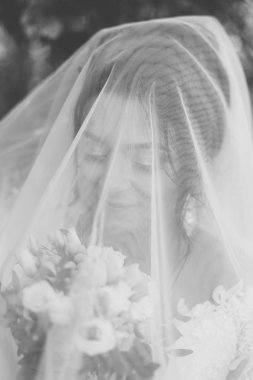 Çok güzel bir gelin buketi tutuyor.