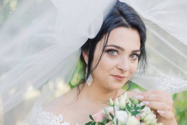 Çok güzel bir gelin buketi tutuyor.