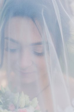 Çok güzel bir gelin buketi tutuyor.