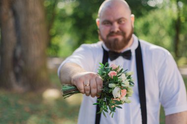 Şık sakallı şişman Damat Düğün buket Park ile.