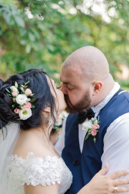 Onların düğün günü üzerinde yeni evliler park, birbirine, gülümseyen bakarak yürüyor.