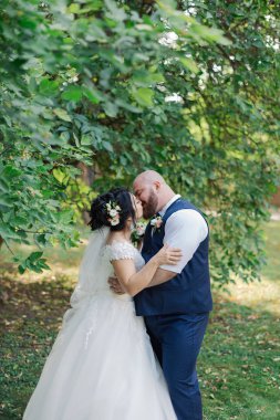 Onların düğün günü üzerinde yeni evliler park, birbirine, gülümseyen bakarak yürüyor.