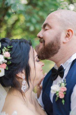 Onların düğün günü üzerinde yeni evliler park, birbirine, gülümseyen bakarak yürüyor.