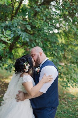 Onların düğün günü üzerinde yeni evliler park, birbirine, gülümseyen bakarak yürüyor.