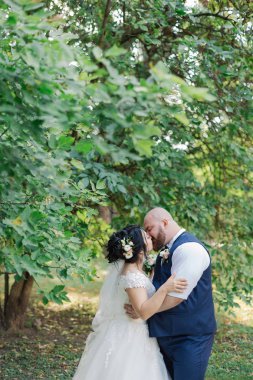 Onların düğün günü üzerinde yeni evliler park, birbirine, gülümseyen bakarak yürüyor.