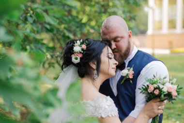 Onların düğün günü üzerinde yeni evliler park, birbirine, gülümseyen bakarak yürüyor.