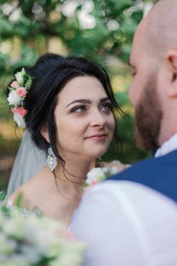 Onların düğün günü üzerinde yeni evliler park, birbirine, gülümseyen bakarak yürüyor.