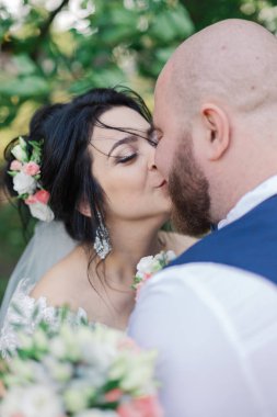 Onların düğün günü üzerinde yeni evliler park, birbirine, gülümseyen bakarak yürüyor.