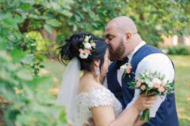 Onların düğün günü üzerinde yeni evliler park, birbirine, gülümseyen bakarak yürüyor.