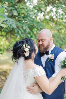 Onların düğün günü üzerinde yeni evliler park, birbirine, gülümseyen bakarak yürüyor.