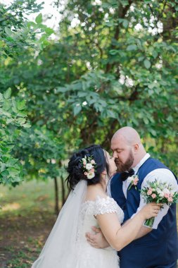 Onların düğün günü üzerinde yeni evliler park, birbirine, gülümseyen bakarak yürüyor.