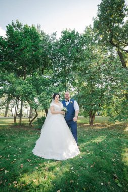 Onların düğün günü üzerinde yeni evliler park, birbirine, gülümseyen bakarak yürüyor.