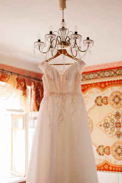 Vestido de novia en la lámpara de araña en la habitación . —  Fotos de Stock