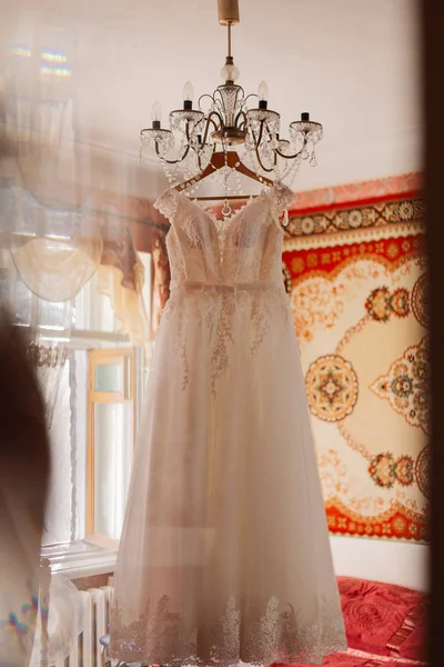 Vestido de novia en la lámpara de araña en la habitación . —  Fotos de Stock