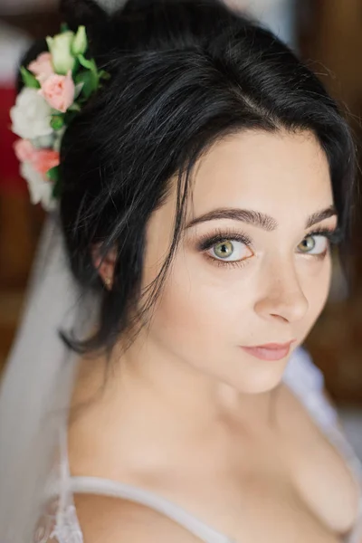 Foto busana pengantin wanita cantik dengan rambut hitam dengan gaun pengantin yang elegan dan diadem berpose di kamar di pagi pernikahan. — Stok Foto