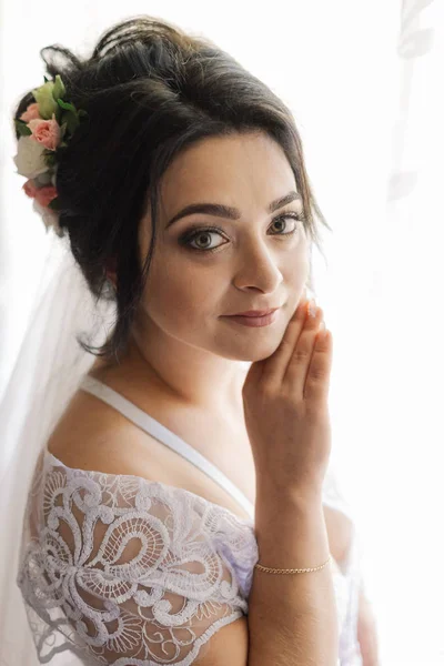 Divat fotó gyönyörű menyasszony sötét haj elegáns esküvői ruha és diadém pózol a szobában az esküvő reggel. — Stock Fotó