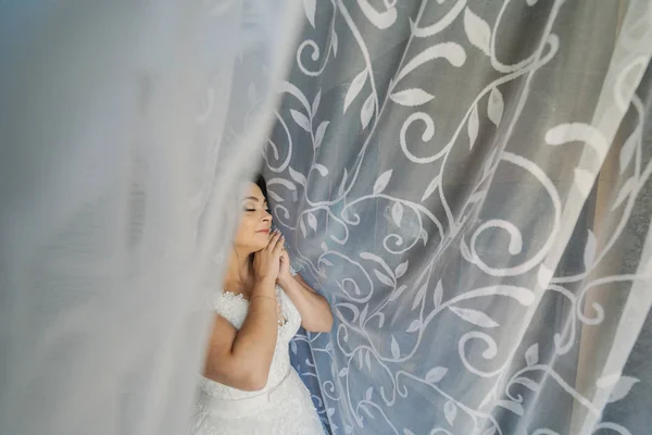 Foto de moda de la novia hermosa con el pelo oscuro en vestido de novia elegante y diadema posando en la habitación en la mañana de la boda. — Foto de Stock