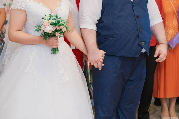 Nowożeńcy, trzymając się za ręce w urzędzie. — Zdjęcie stockowe