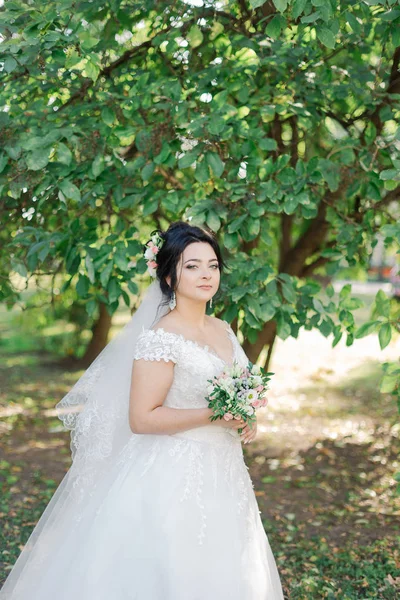 Hermosa novia en un hermoso vestido y ramo . —  Fotos de Stock