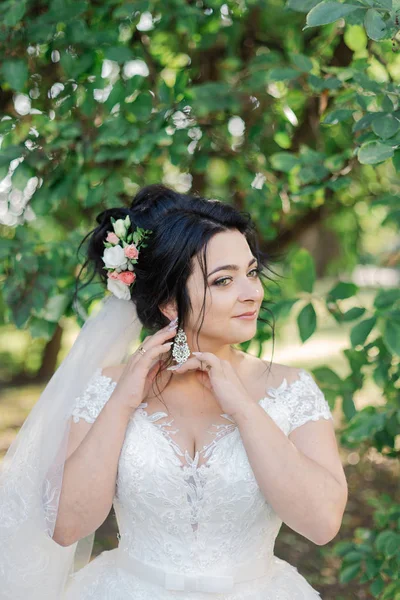 Foto busana pengantin wanita cantik dengan rambut hitam dengan gaun pengantin yang elegan dan diadem berpose di kamar di pagi pernikahan. — Stok Foto