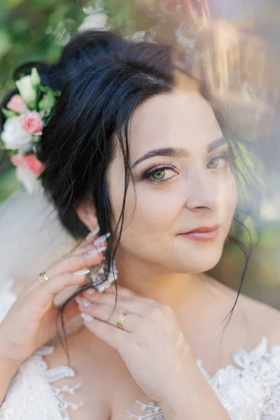 Foto busana pengantin wanita cantik dengan rambut hitam dengan gaun pengantin yang elegan dan diadem berpose di kamar di pagi pernikahan. — Stok Foto