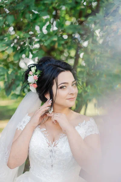 Módní fotografie krásné nevěsty s tmavými vlasy v elegantních svatebních šatech a diadémem pózování v pokoji ve svatební ráno. — Stock fotografie