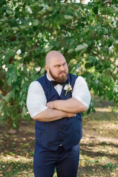 Stylish bearded fat groom in the park. — Stock Photo, Image