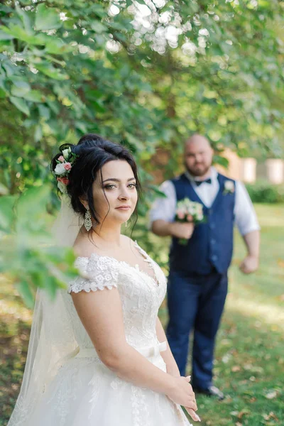 Newlyweds on their wedding day stand apart from each other.